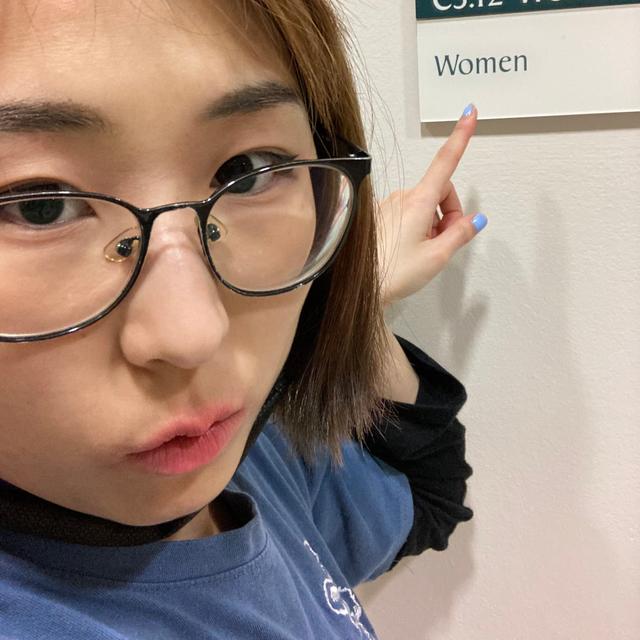 helia pointing at a sign saying "Women"